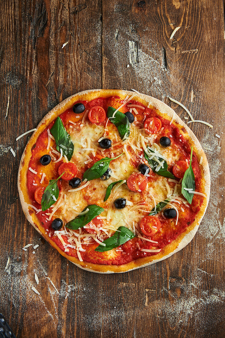 Pizza Milano mit Kirschtomaten, Oliven und Basilikum