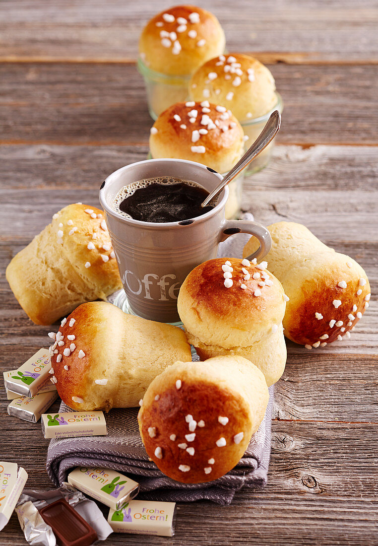 Kleine süsse Hefe-Milchbrötchen aus dem Weckglas mit Hagelzucker und Tasse Kaffee zu Ostern