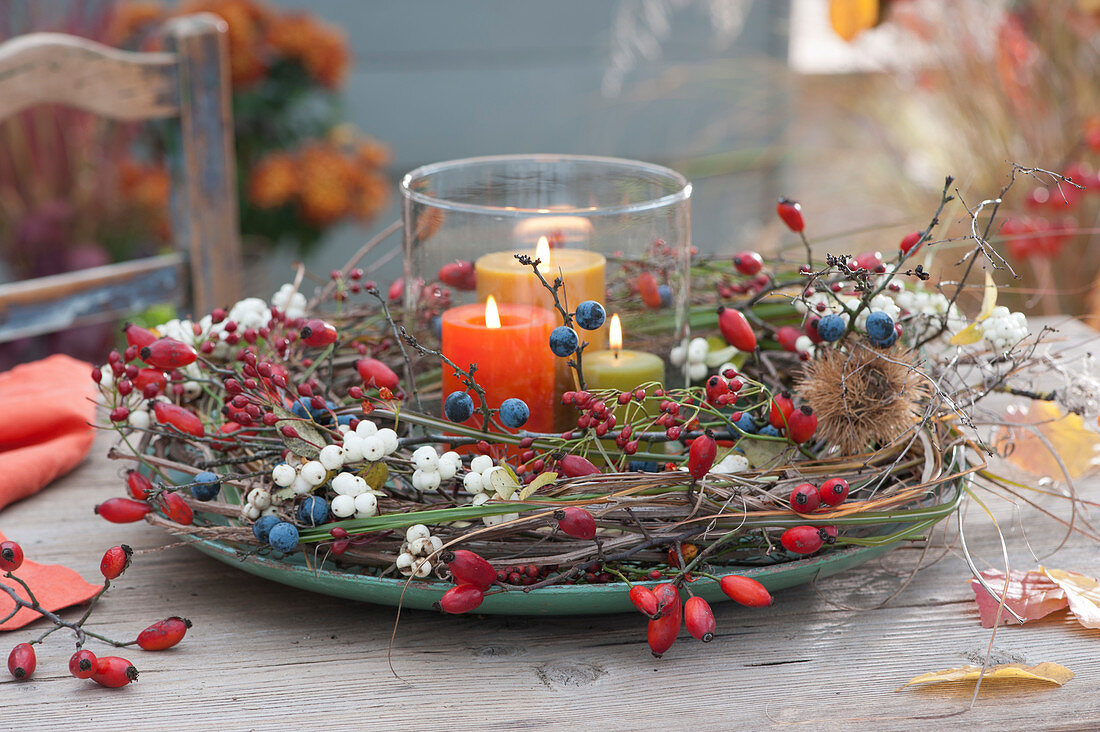 Lantern in the autumn wreath with rose hips, snow berries and sloes