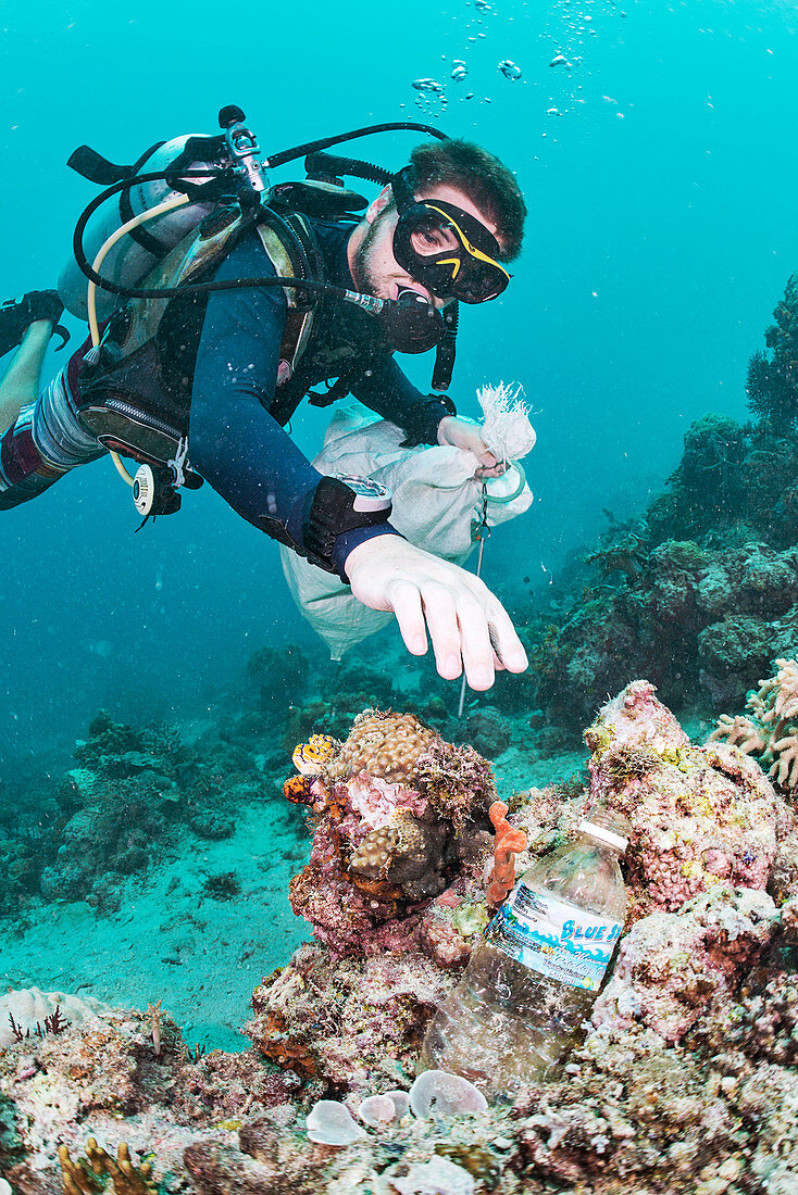 Scuba diver collecting waste plastic bottle