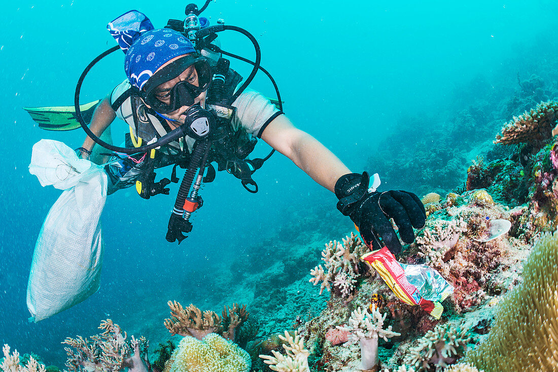 Scuba diver collecting waste food wrapper