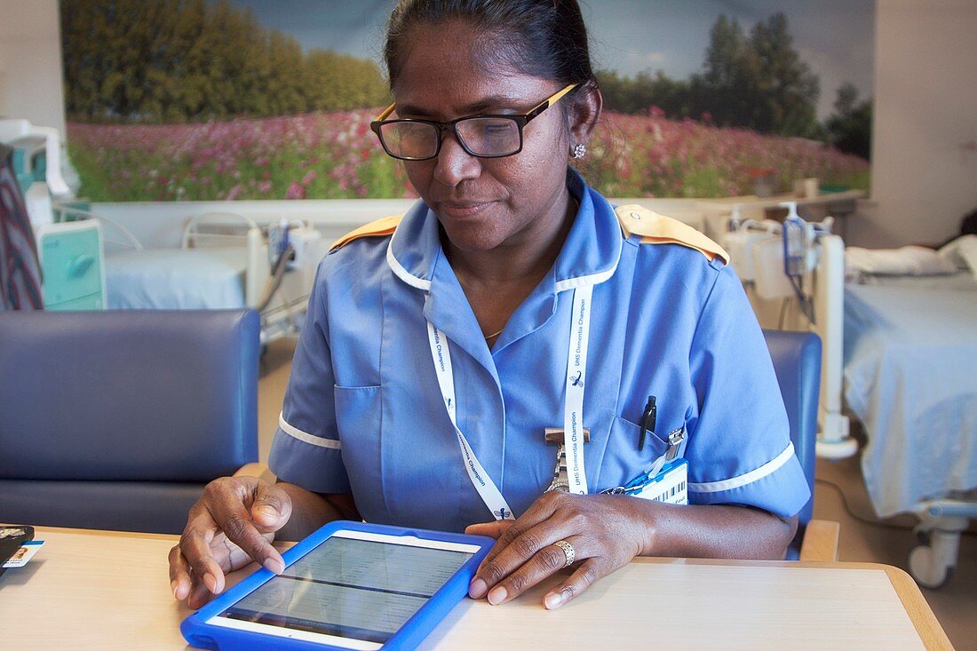 Nurse recording patient care on a tablet computer