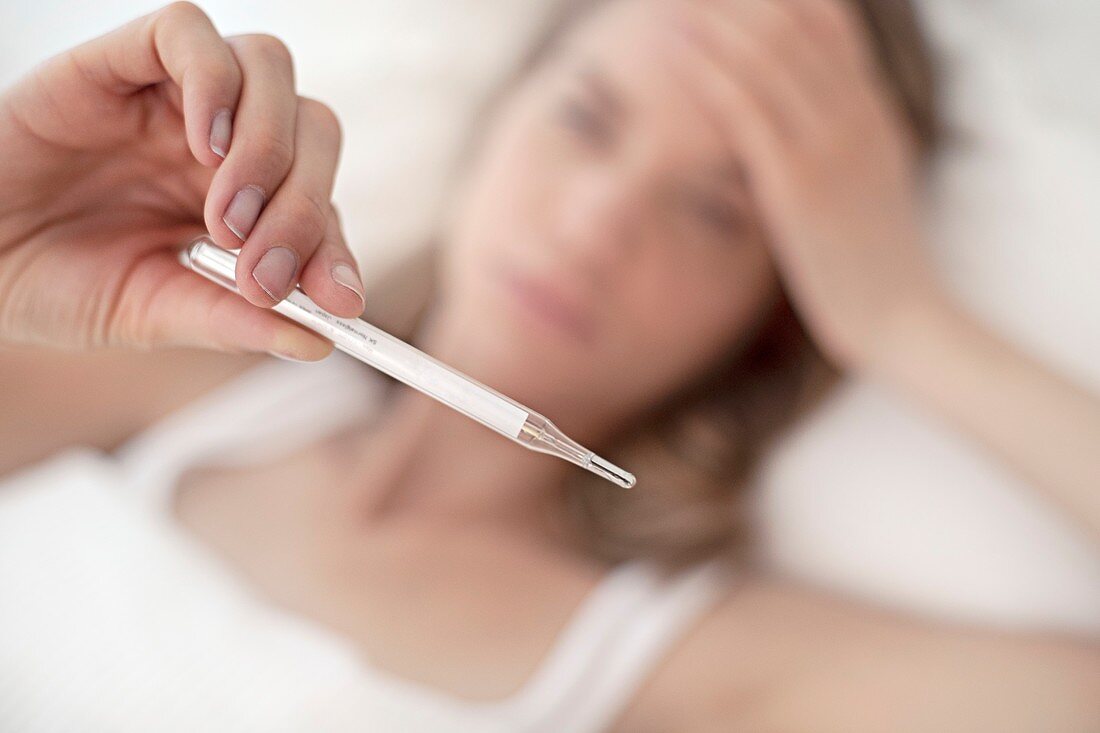 Young woman taking her temperature