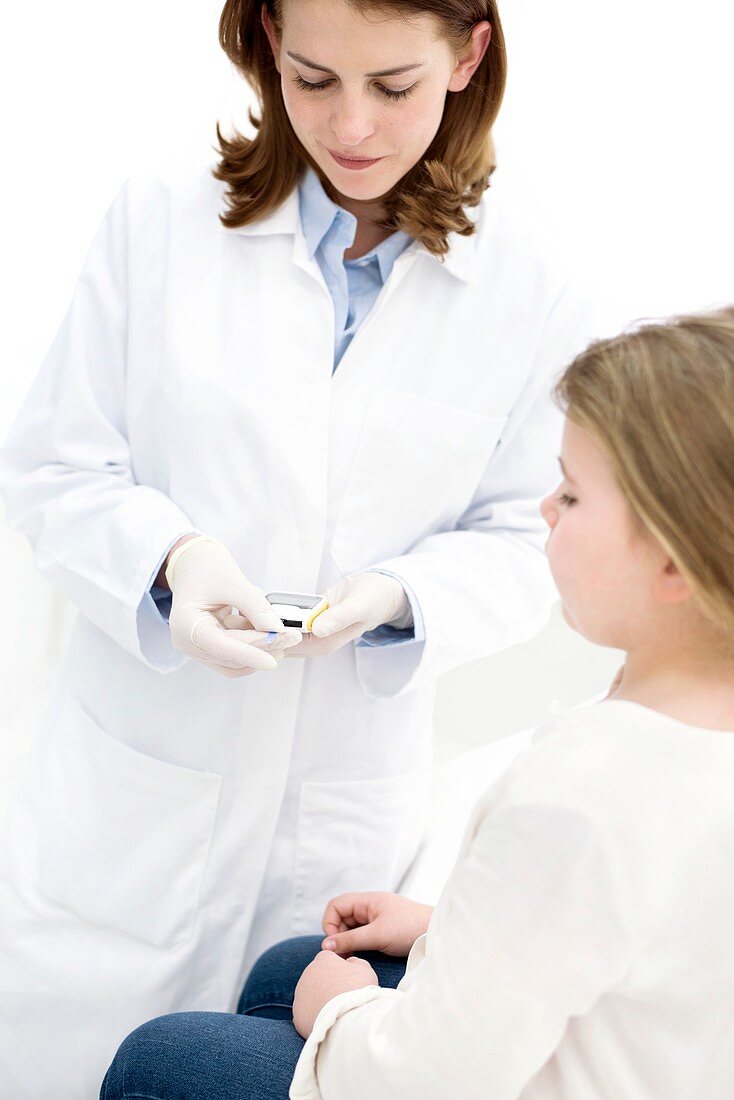 Doctor testing girl using finger prick test