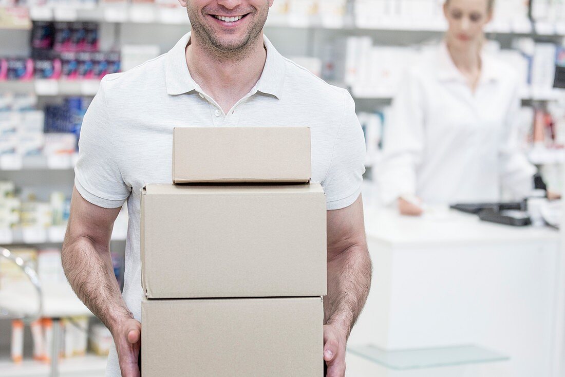 Courier carrying boxes in pharmacy