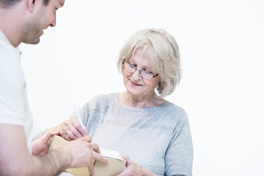 Senior woman signing for a delivery