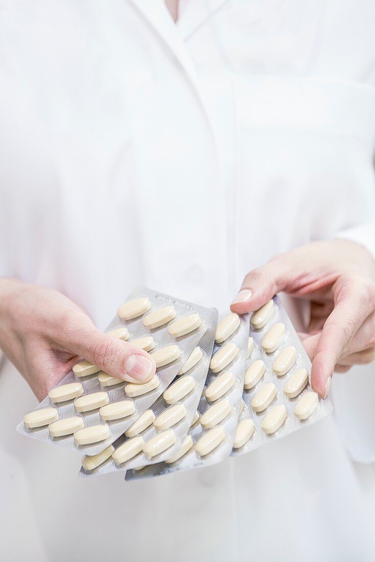 Pharmacist holding pills in blister packs