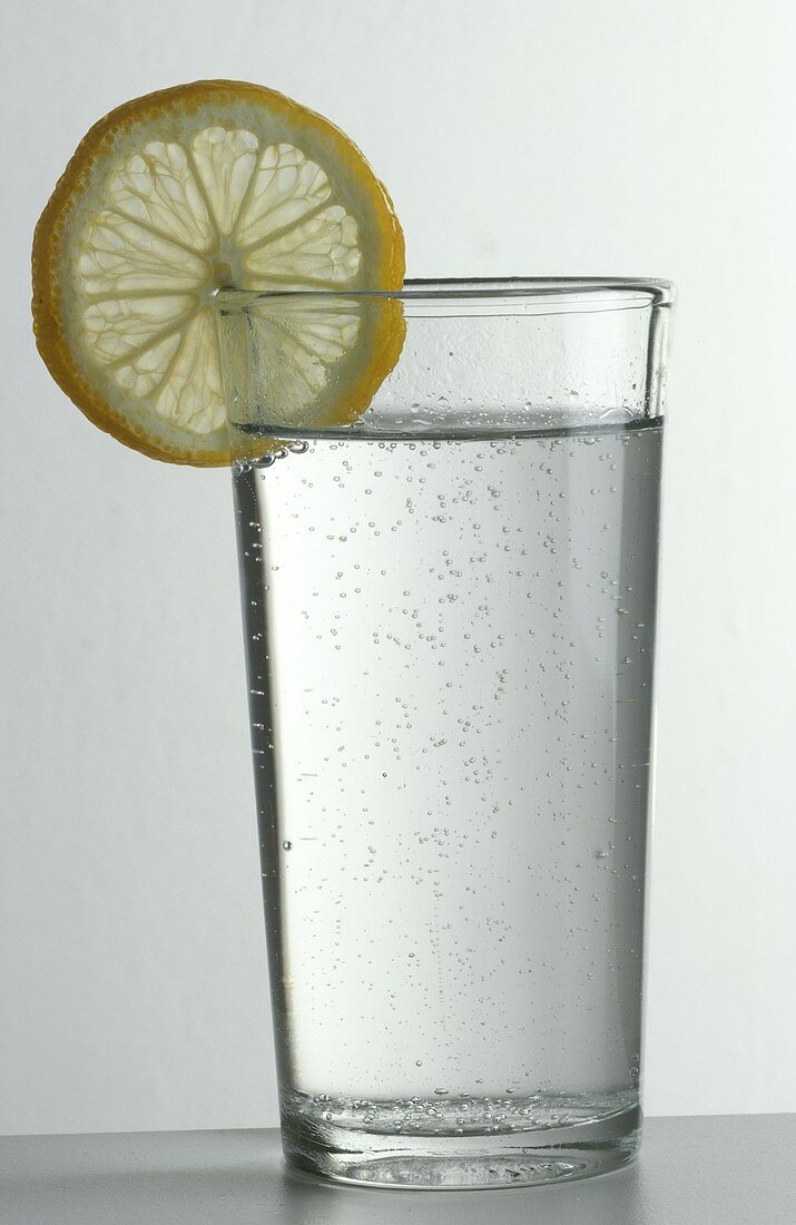 Glas Mineralwasser mit wenig Sprudel & Zitronenscheibe