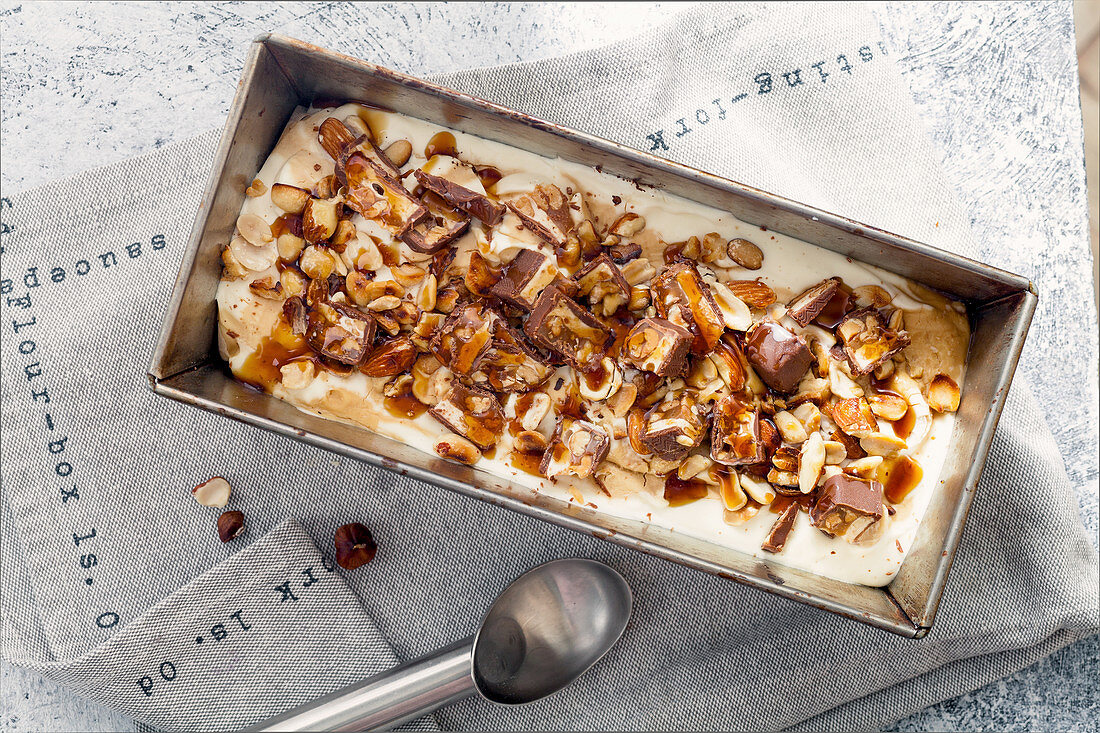 Eiscreme mit Schoko-Karamell-Riegel, gebratenen Erdnüssen und Haselnüssen