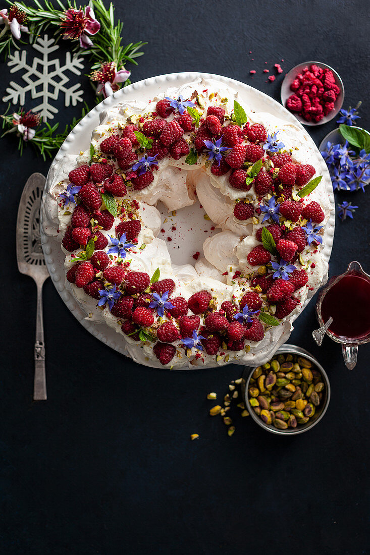 Festive pavlova with raspberries, pistachios and borage flowers