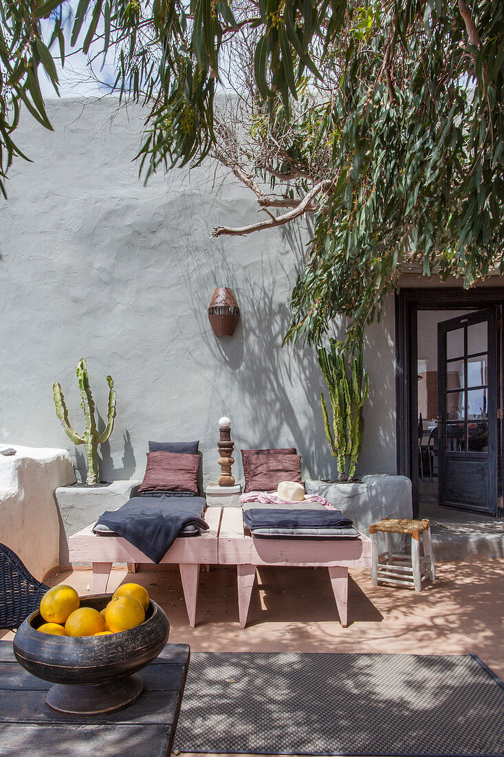 Loungers in dappled shade on Mediterranean terrace