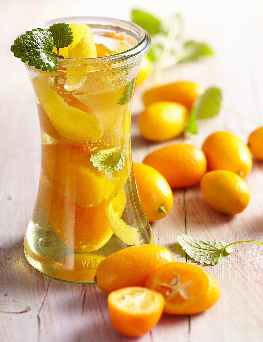Homemade kumquat vinegar with fresh fruit and lemon balm