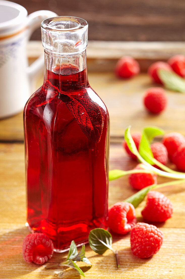 Homemade raspberry vinegar with fresh raspberries, sage, lemon balm, peppermint and white wine vinegar