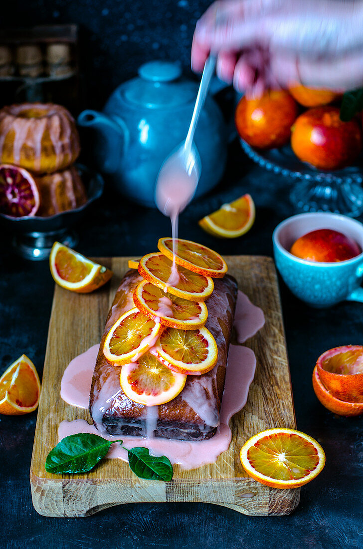 A pound cupcake with a red orange frosting and red orange slices