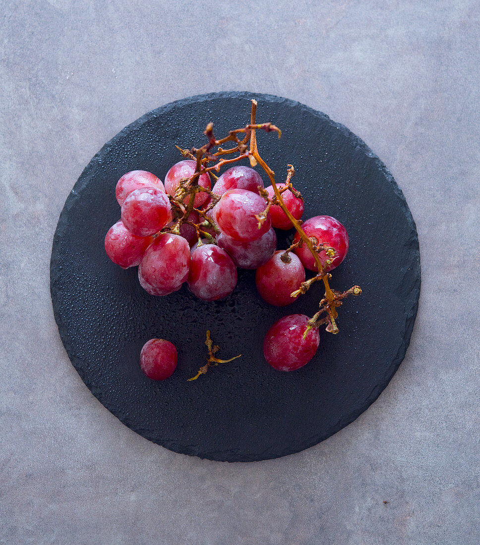 Red grapes on a stone plate