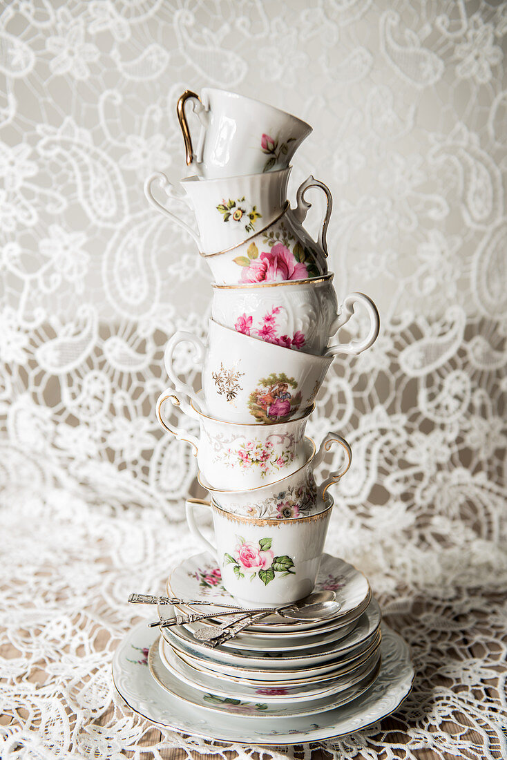 Stack of vintage cups and plates with floral motifs