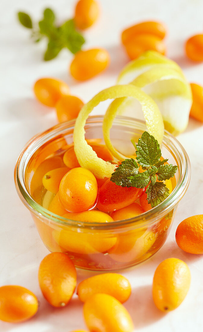 Homemade kumquat vinegar with lemon peel and mint