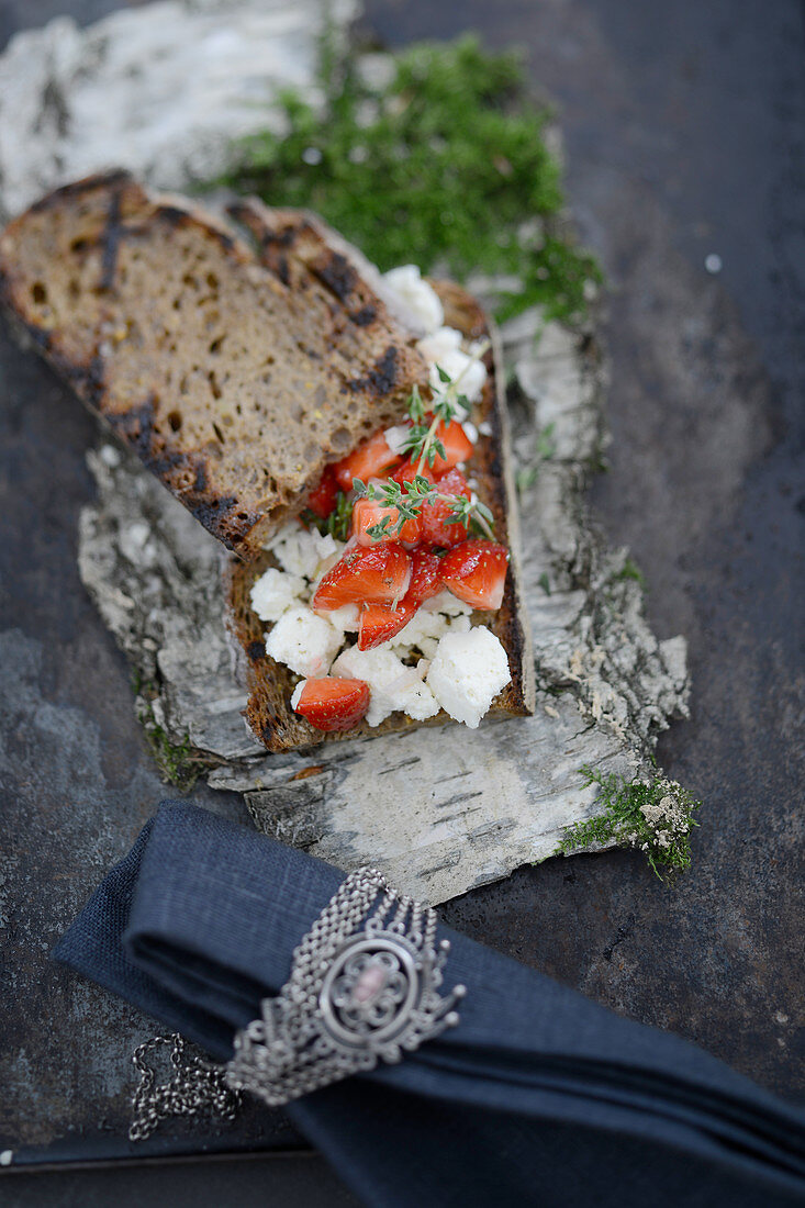 Grilled bread with marinated cheese and strawberries