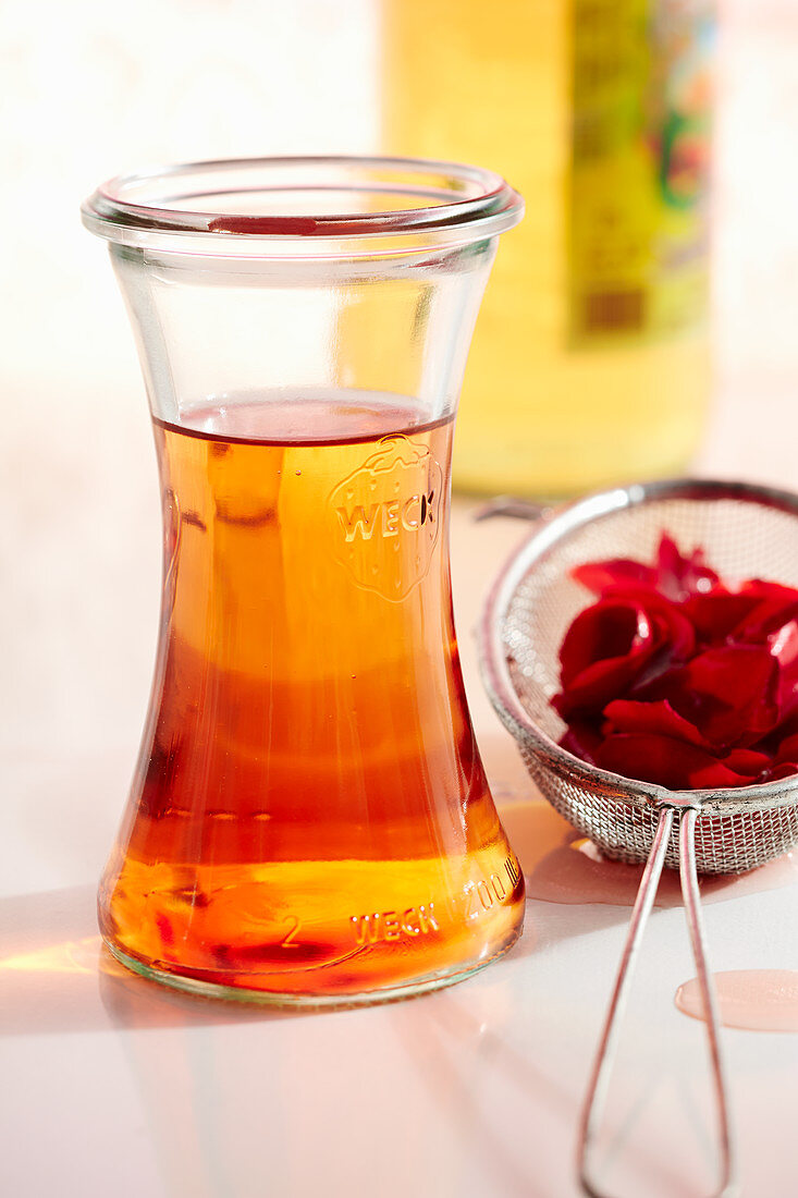 Homemade rose blossom vinegar in a mason jar with Aceto Balsamico Bianco