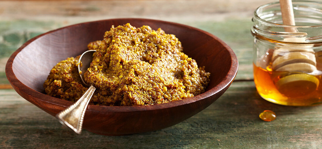 Homemade coarse sweet mustard with honey and chilli in a wooden bowl