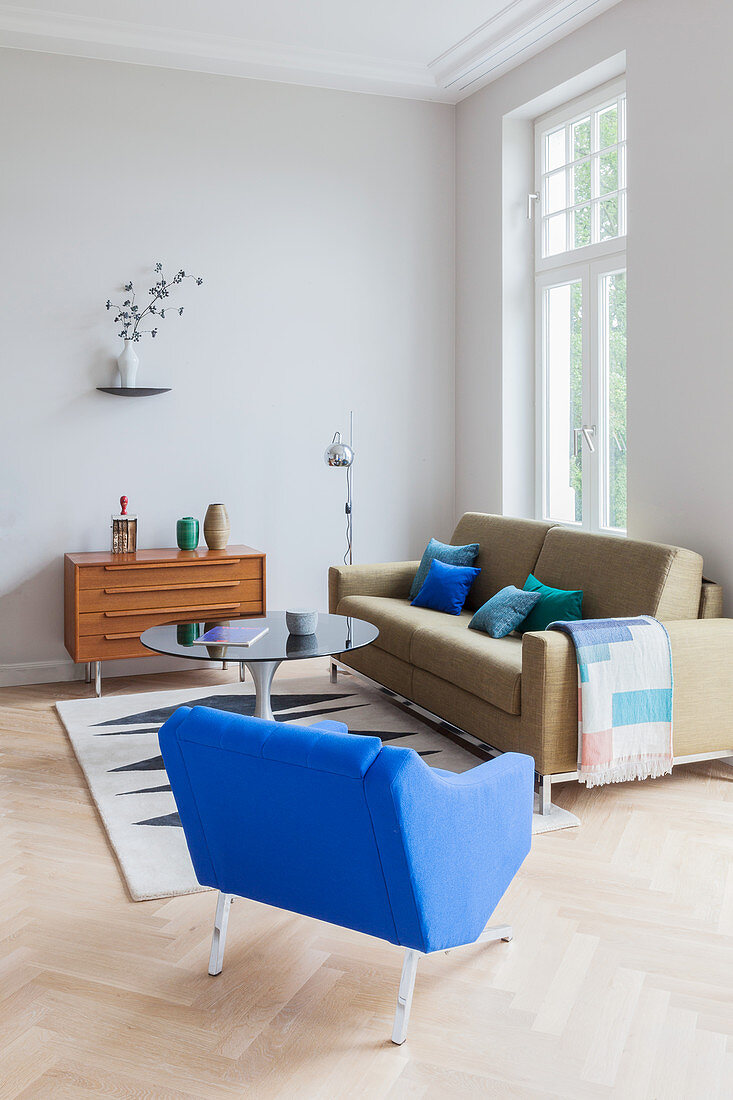 Sofa, armchair, round coffee table and sideboard in period apartment