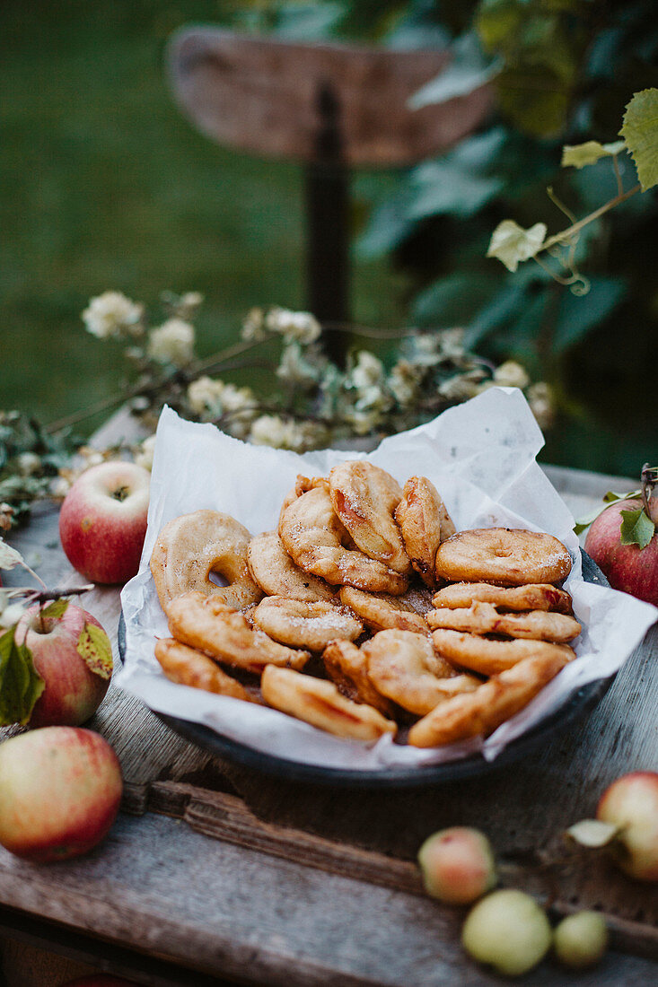 Baked apple rings on a wooden table in a garden