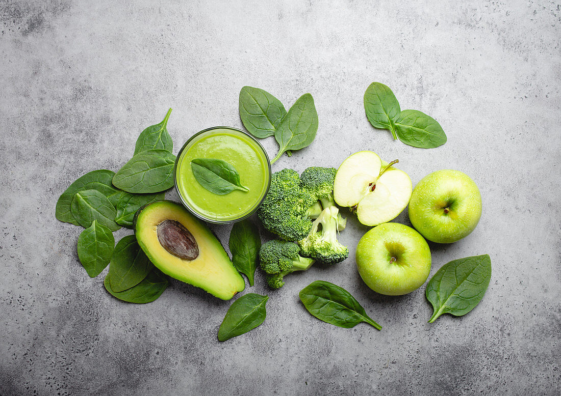 Ingredients for making green healthy smoothie with broccoli, apples, avocado and spinach