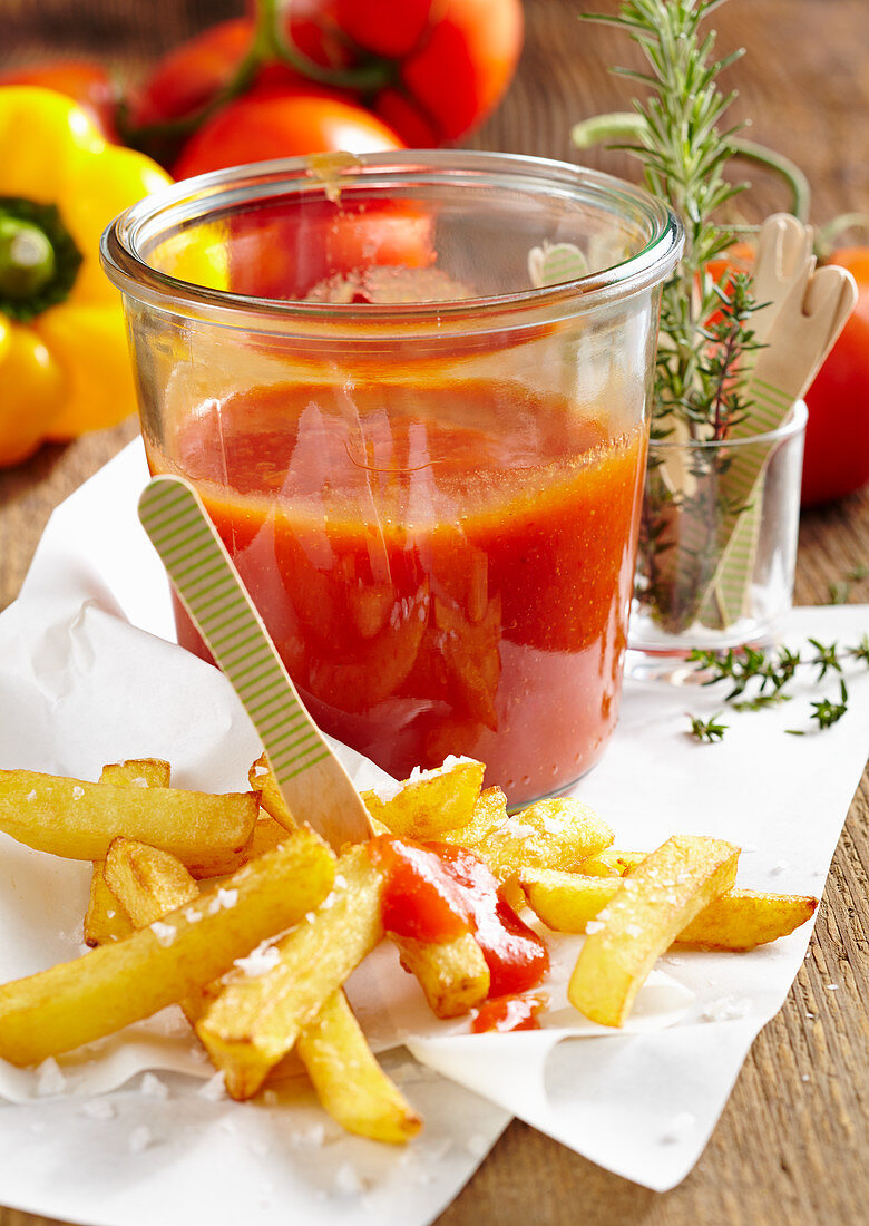 Selbstgemachter Tomaten-Paprika-Ketchup im Glas zu Pommes frites