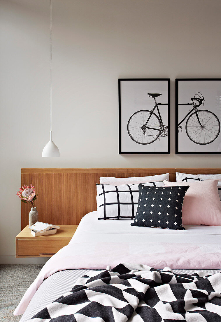 Double bed with headboard and integrated bedside table, two-part picture with bike motif above