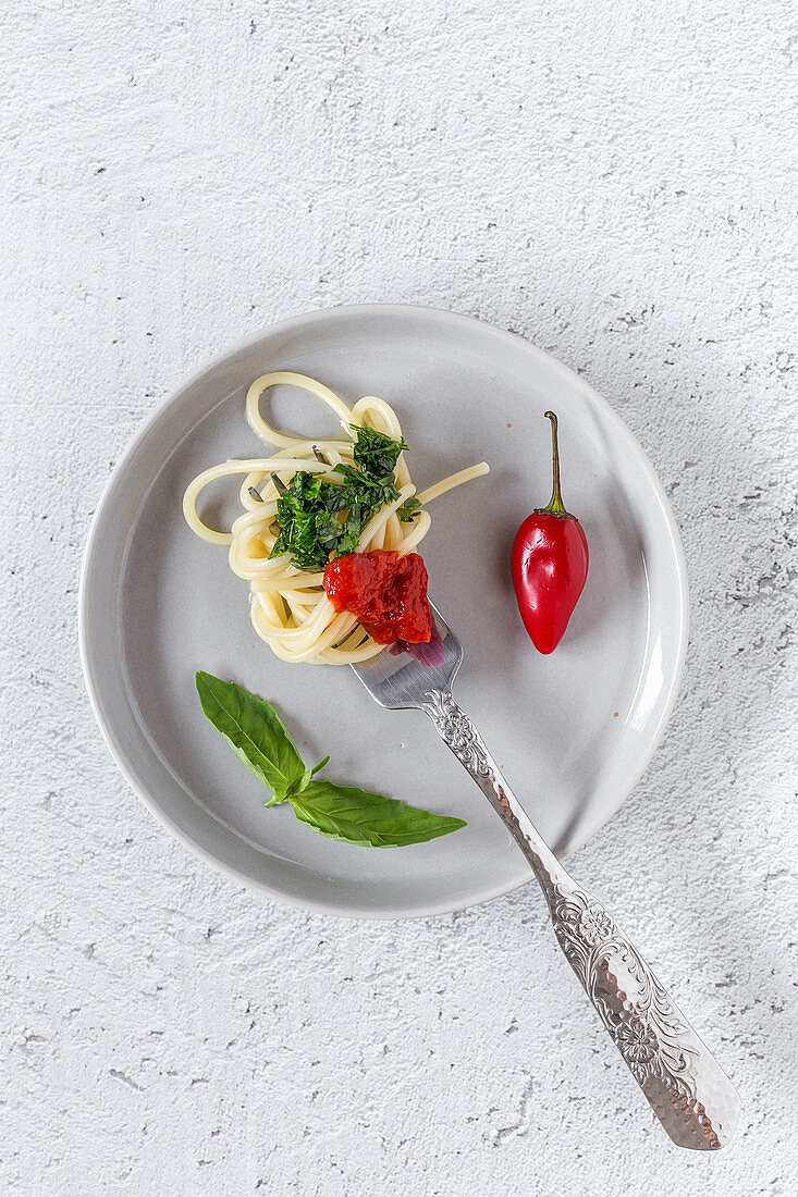 Spaghetti with tomato sauce on white background