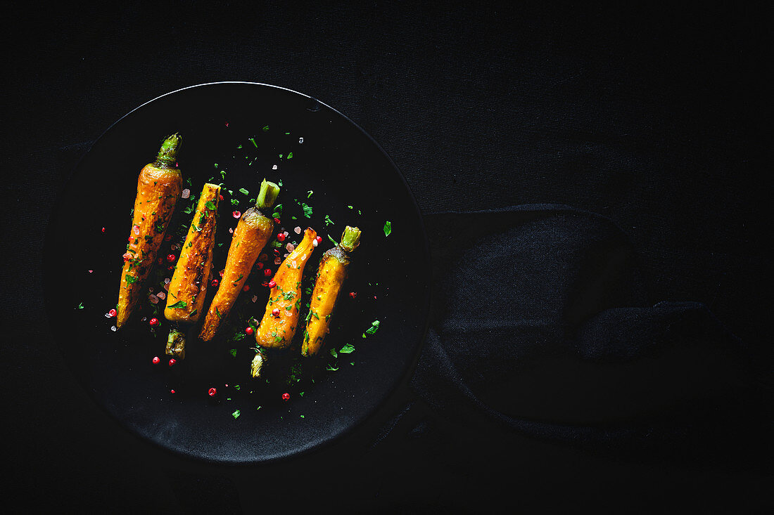 Healthy roasted carrots on dark background