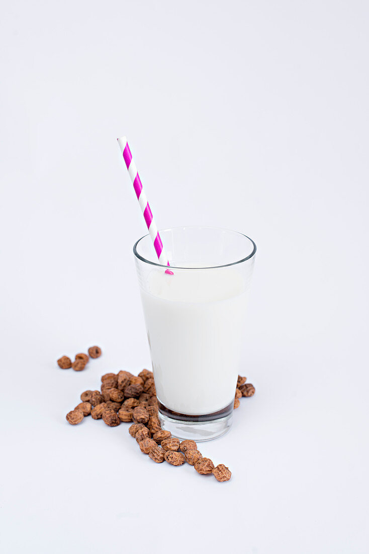 Milchglas mit Trinkhalm und Rosinen