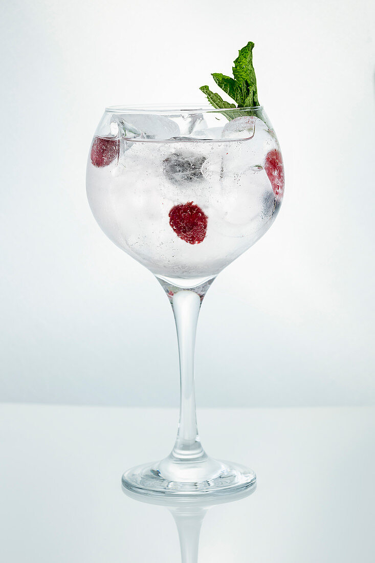 Cocktail mit Himbeeren, Eiswürfeln und Minze