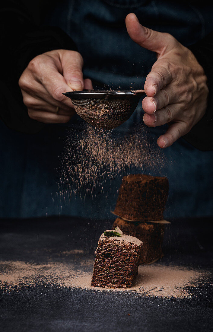 Schokoladenbrownies werden mit Kakao bestäubt