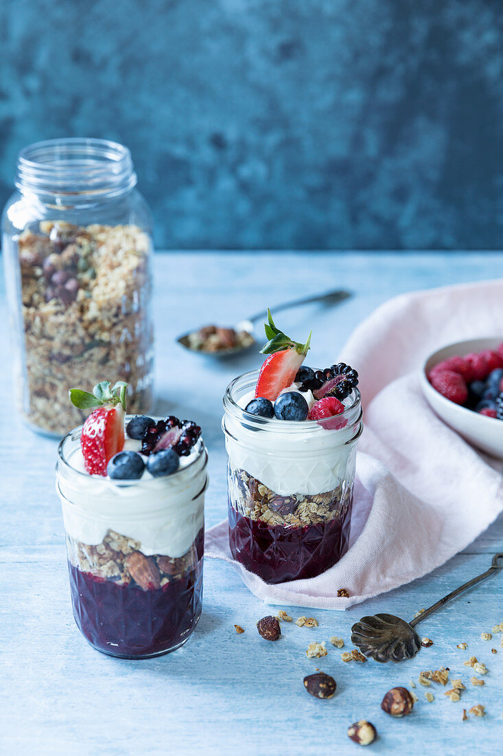 Oat granola with nuts and dreid fruit with fruit puree, berries and yogurt