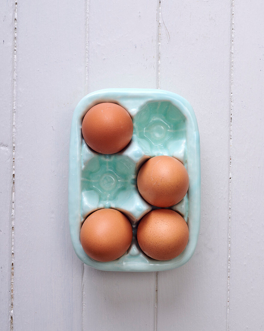 Vier Eier in Porzellan-Eierbehälter