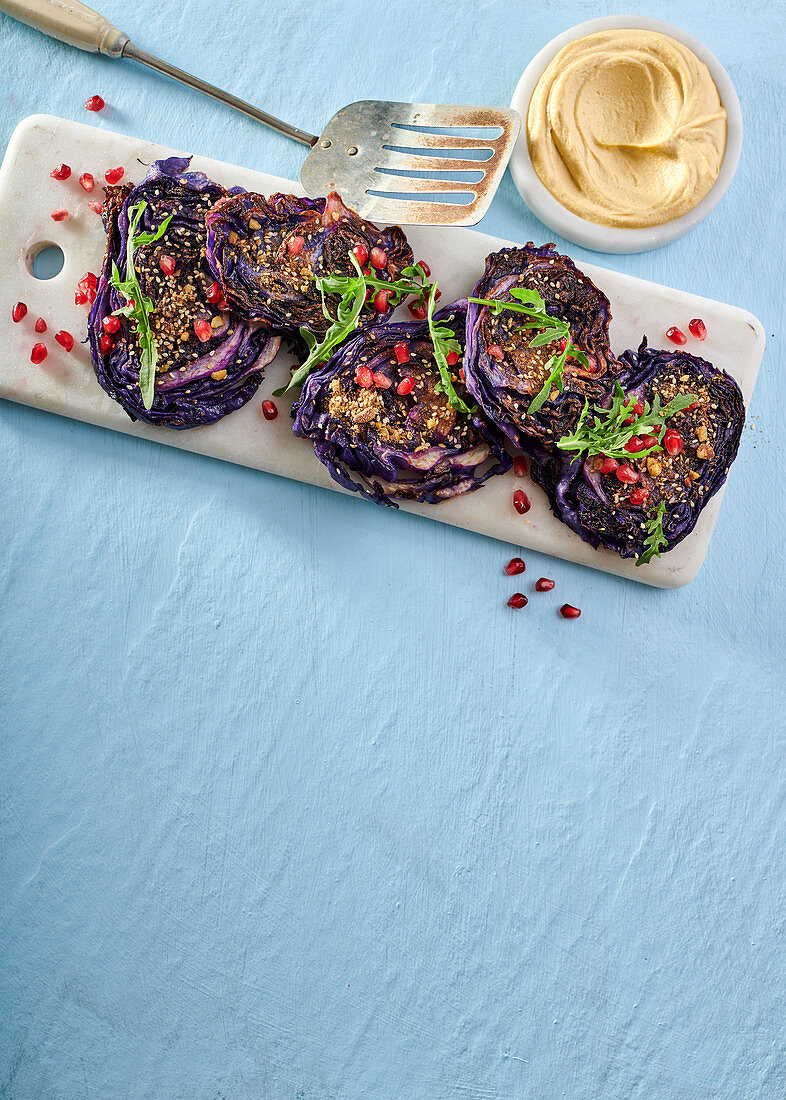 Gebratene Rotkohl-Steaks mit Dukkah, Granatapfelkernen und Hummus