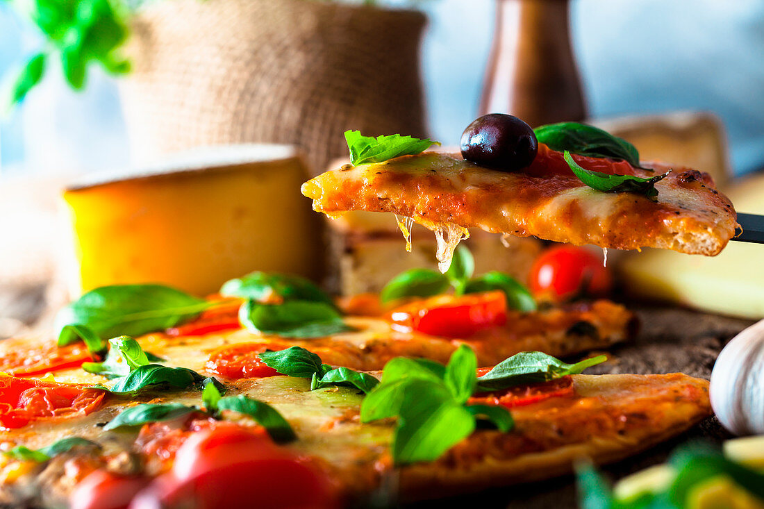 Pizza mit Käse, Tomaten, Oliven und Basilikum (Italien)