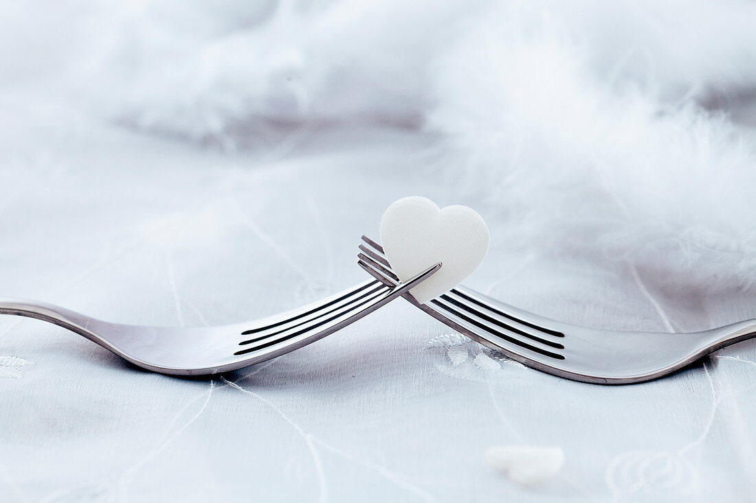 Zwei Gabeln mit weißem Herz (Symbolbild zum Valentinstag)