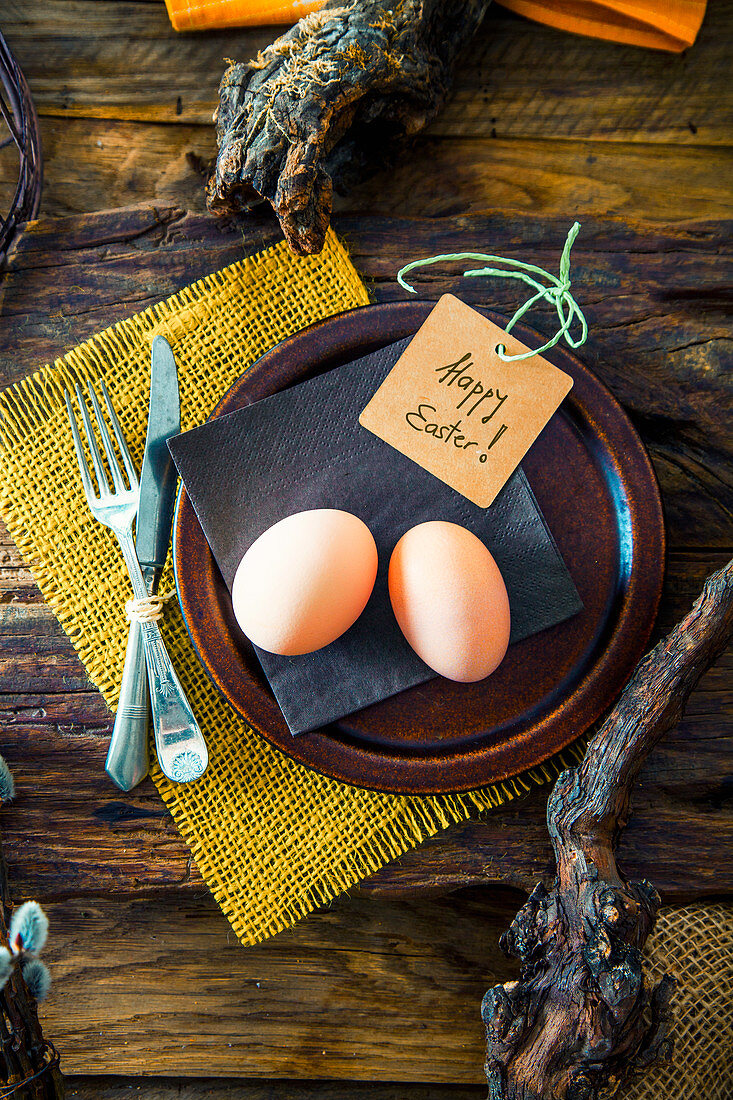 A rustic Easter table setting with knotty branches and fresh eggs