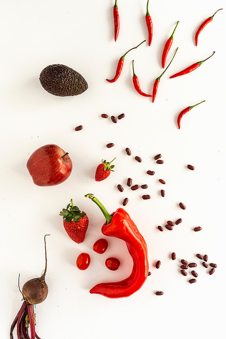 Mix of fruits and vegetables in red color on white background