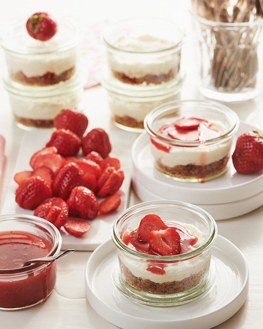 Kleine Erdbeer-Cheesecakes in Gläsern mit Amarettiniboden
