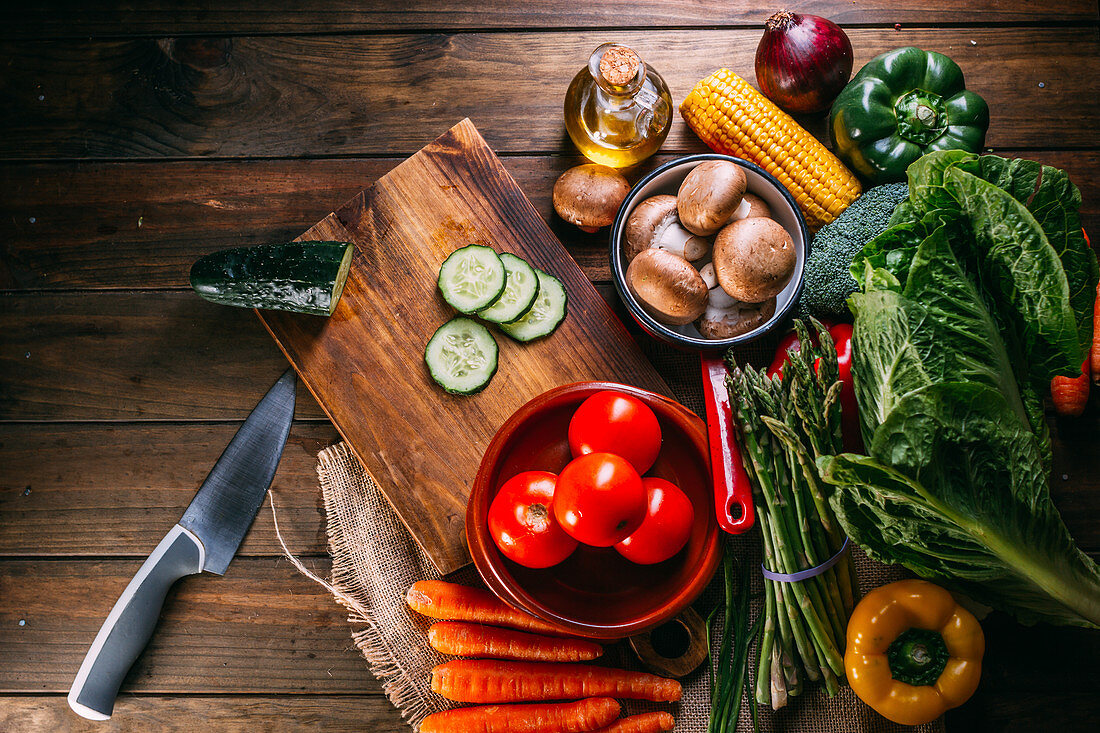 Verschiedenes Gemüse, Pilze und Salat auf Holztisch