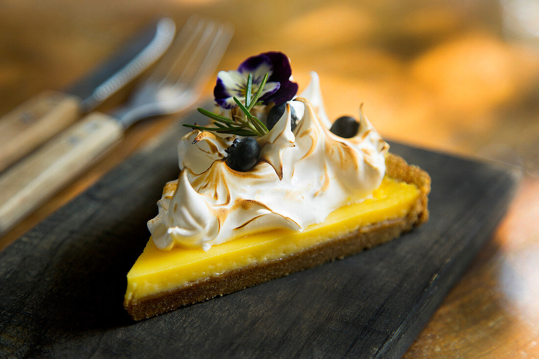 Ein Stück Lemon Pie mit Meringue und Blaubeeren