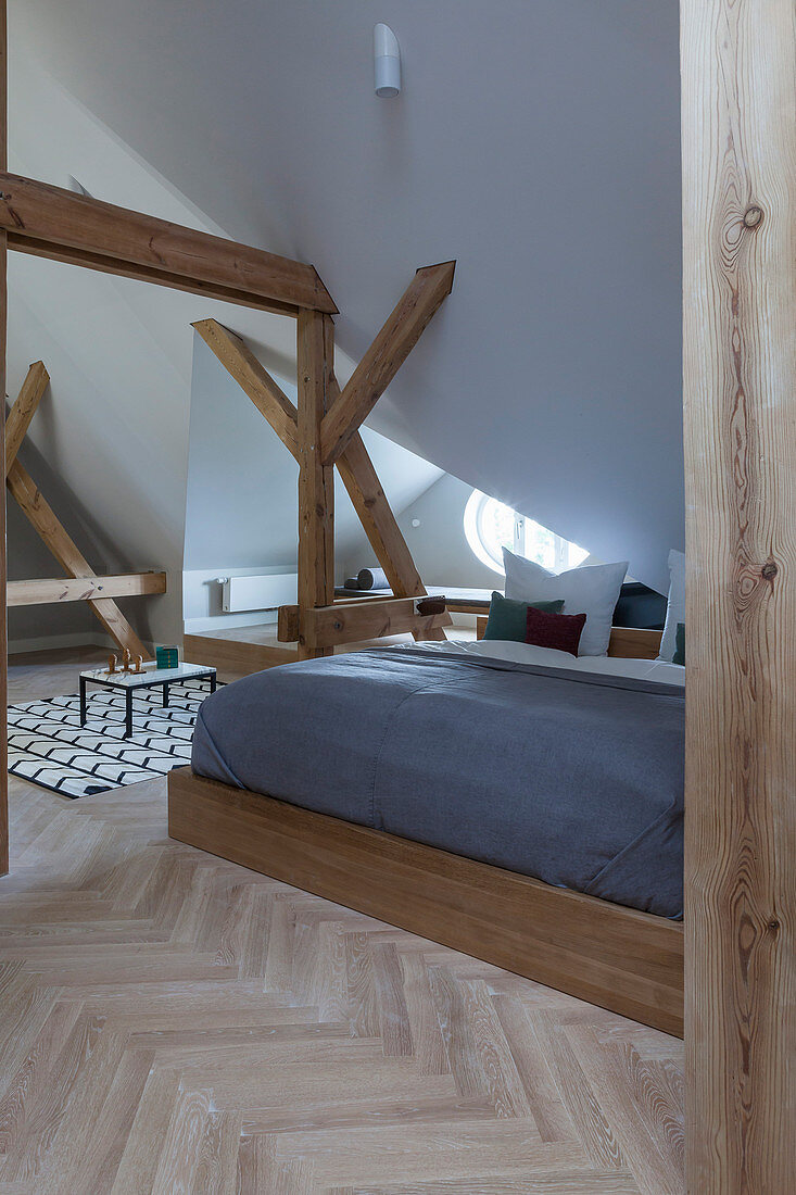 Wooden double bed in attic bedroom