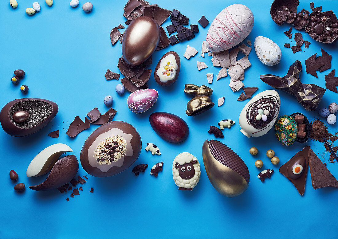 Whole and broken easter eggs on a blue background