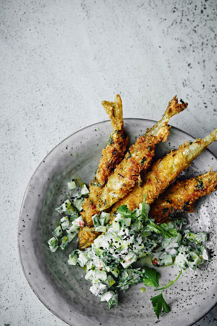 Small fried fish with a cucumber and yoghurt salad