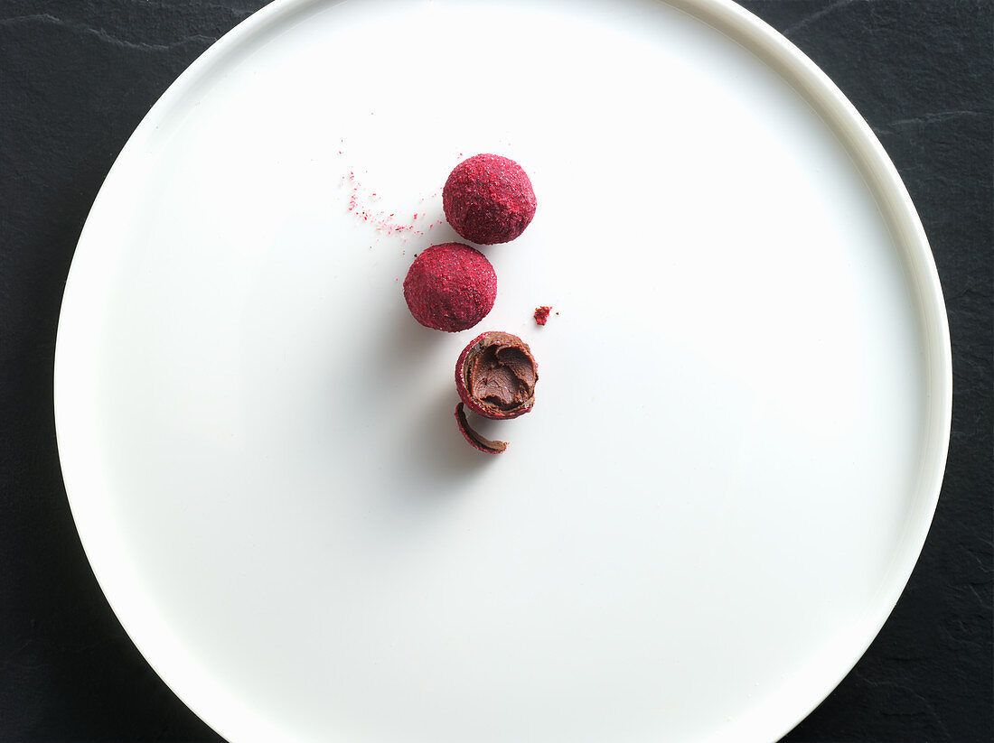 Raspberry truffles on a white plate