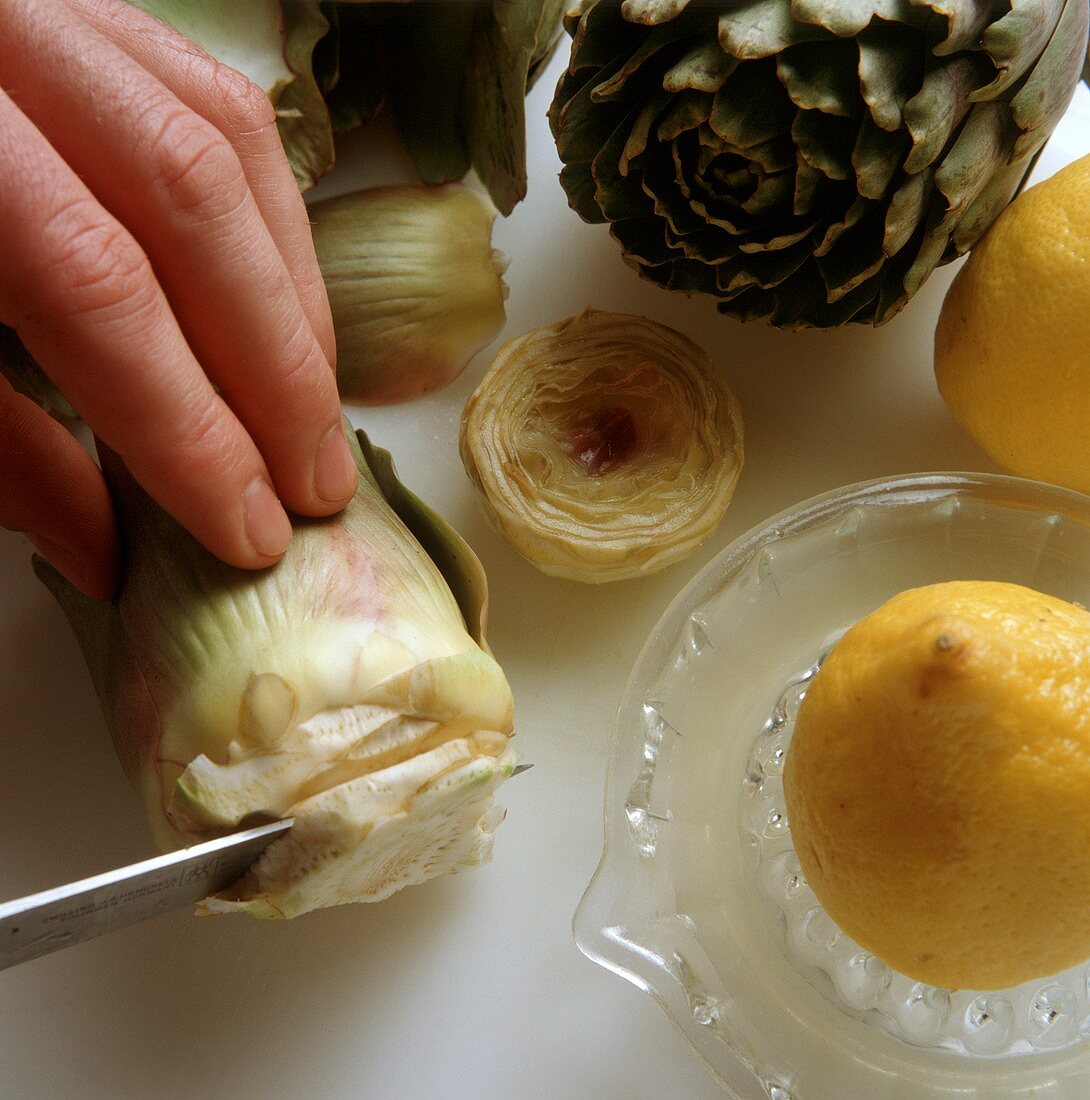 Cutting artichokes & rubbing cut surfaces with lemon juice