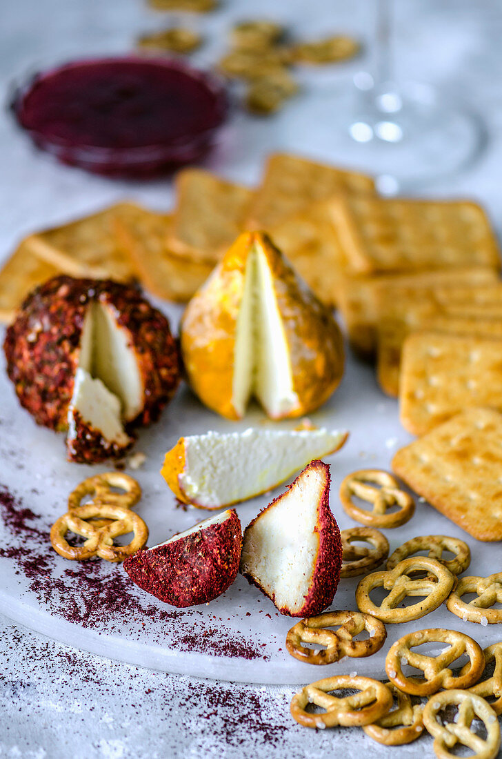 Goat cheese with hot pepper and turmeric and a cracker on a marble pedestal